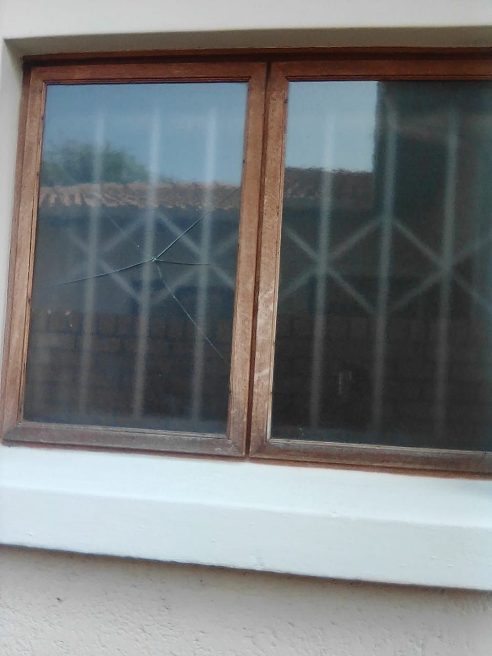 A wooden window with a crack running across the left pane